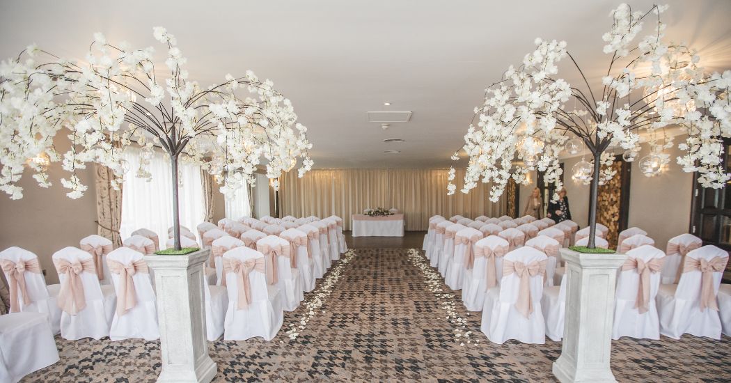 Wedding venue decor in white, with blossom trees