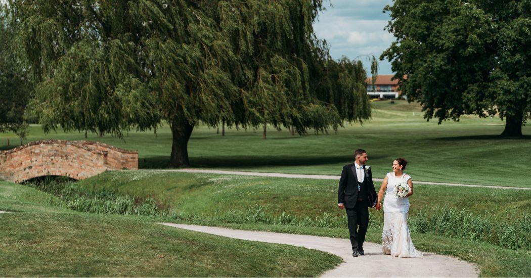 Married couple walking through Nottingham golf course wedding venue