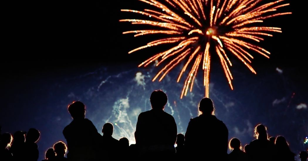 Fireworks in the sky, with the silhouette of spectators