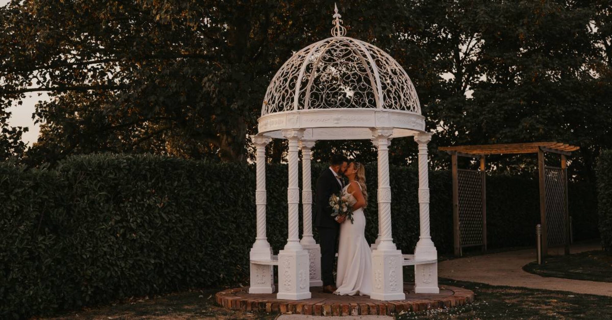 wedding couple kissing under a gazebo