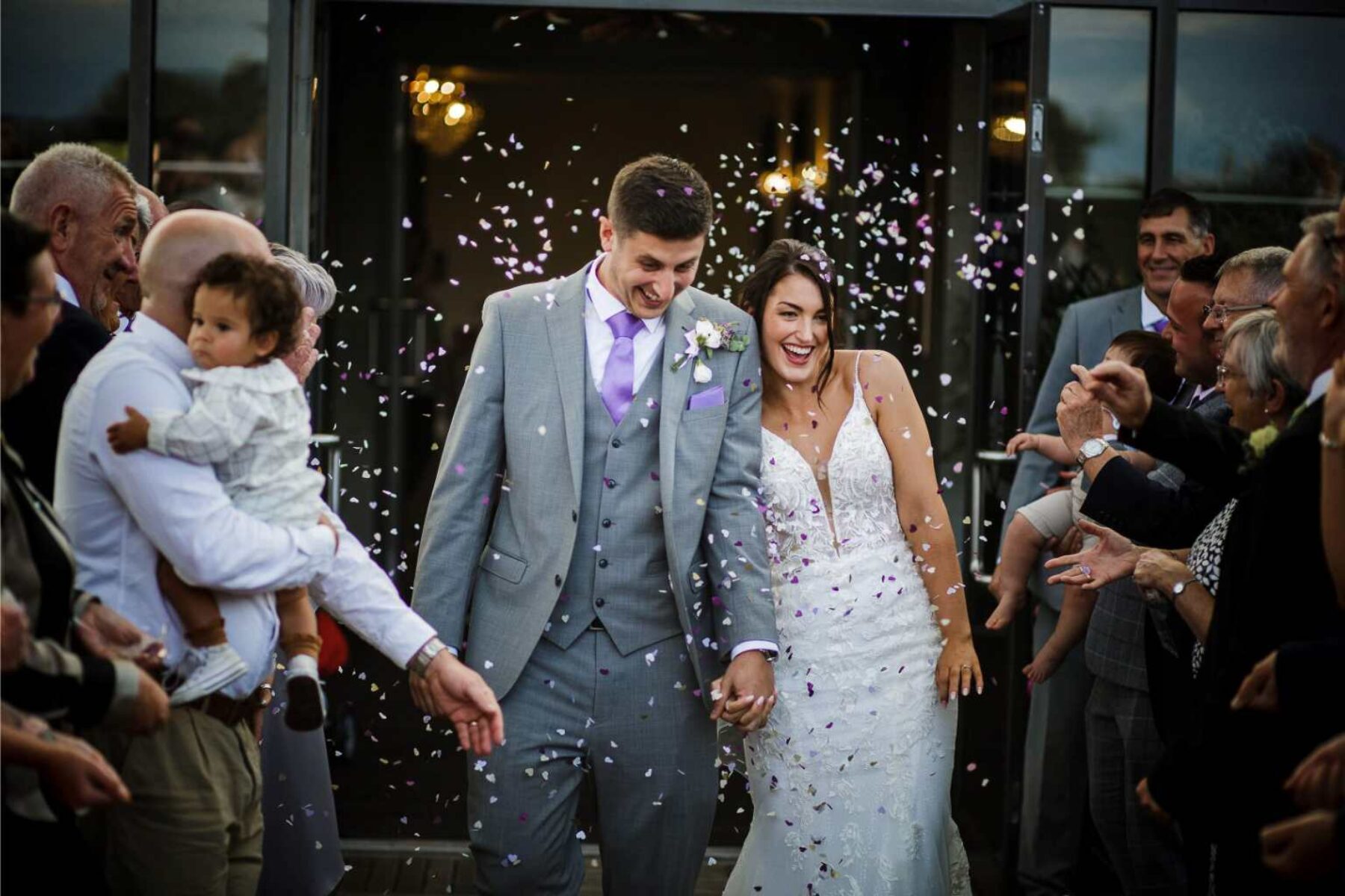 just married couple having their exit ceremony greeted by family and friends